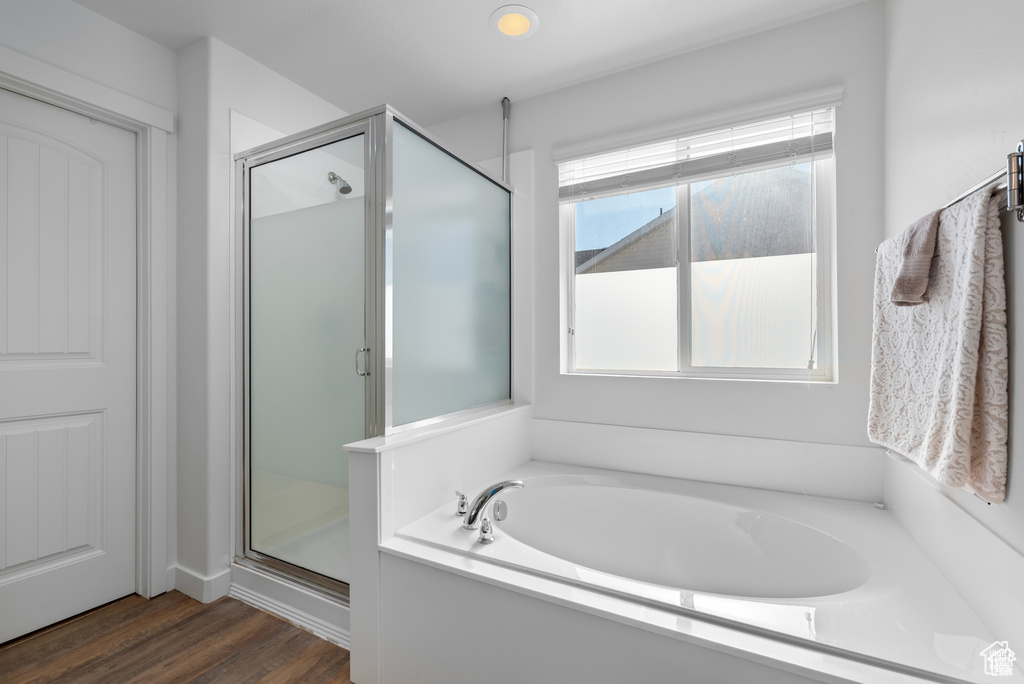 Full bathroom with a garden tub, a shower stall, and wood finished floors