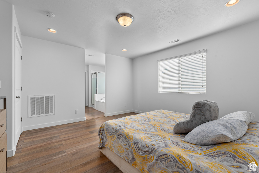Bedroom with wood finished floors and recessed lighting