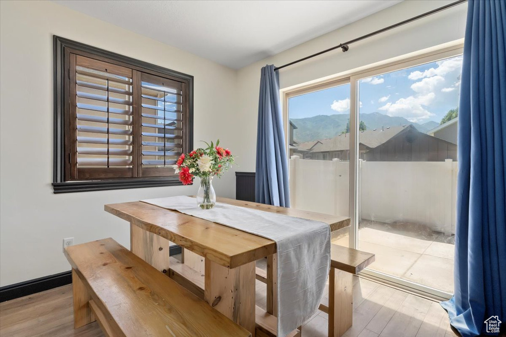 Dining area with plenty of natural light, wood finished floors, and a mountain view