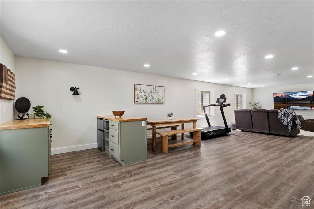 Workout room with dark wood-type flooring and recessed lighting