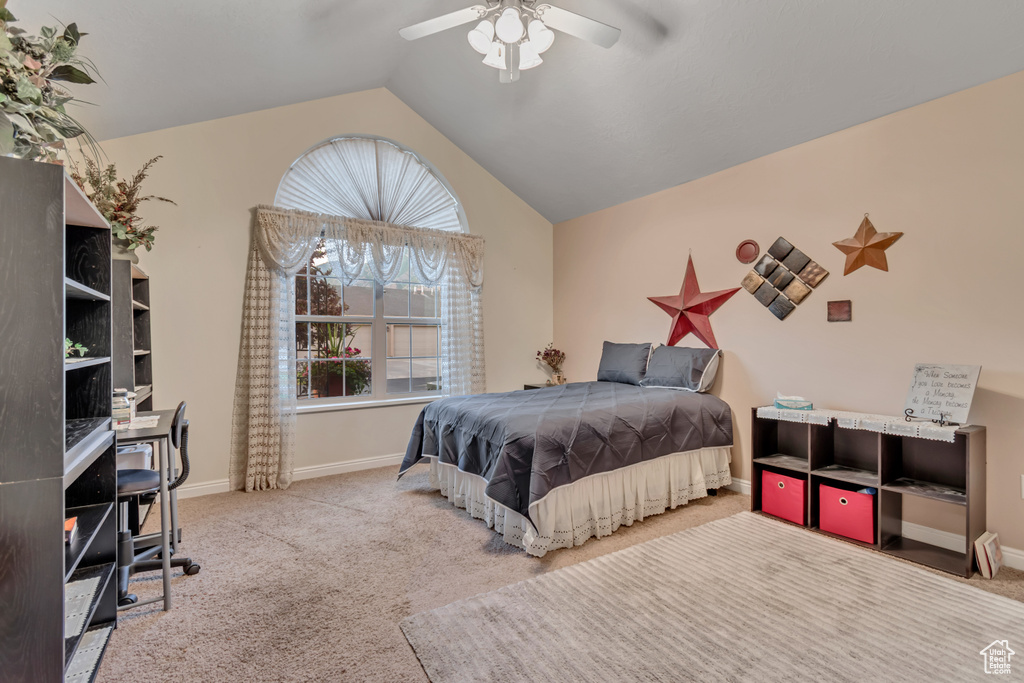 Carpeted bedroom with lofted ceiling, a desk, and ceiling fan