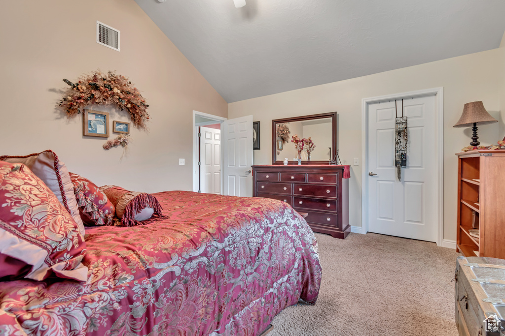 Carpeted bedroom featuring high vaulted ceiling and baseboards