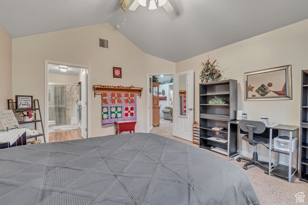 Bedroom featuring vaulted ceiling, an office area, ensuite bathroom, and a ceiling fan