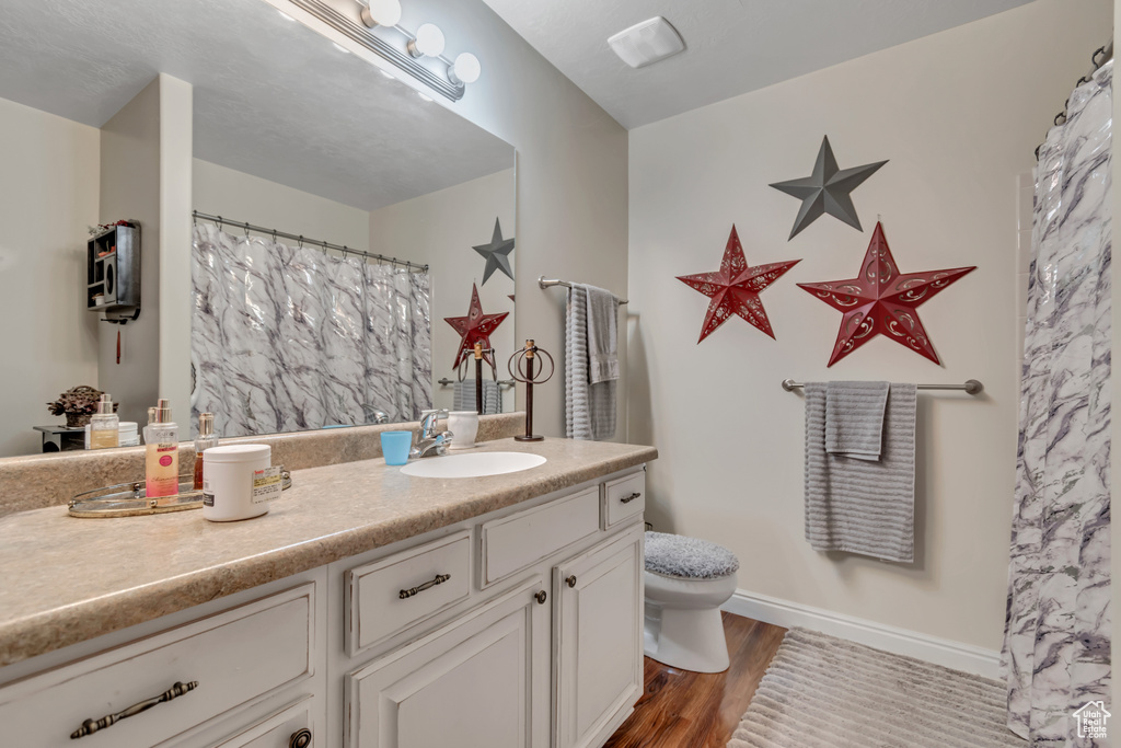 Full bathroom featuring vanity and wood finished floors