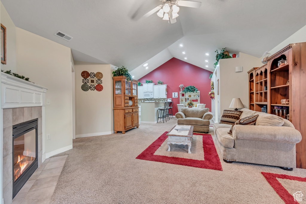 Living room with a fireplace, ceiling fan, lofted ceiling, recessed lighting, and light colored carpet