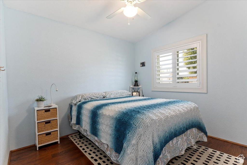 Bedroom with wood finished floors, lofted ceiling, and ceiling fan