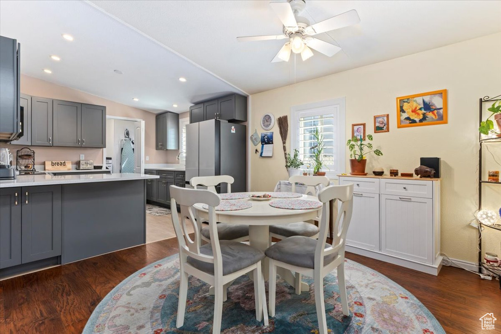 Dining area with dark wood-type flooring, vaulted ceiling, ceiling fan, and recessed lighting