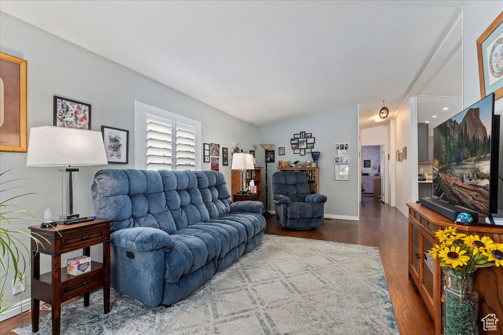 Living room with wood finished floors and vaulted ceiling