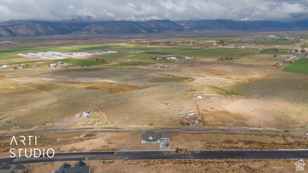 Aerial overview of property's location featuring a mountainous background and rural landscape