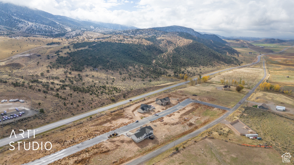 Aerial view of property's location featuring a mountain backdrop and rural landscape