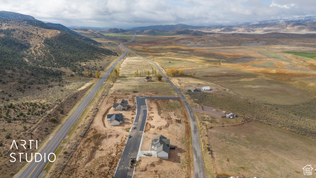Aerial view of property's location featuring a mountain backdrop and rural landscape