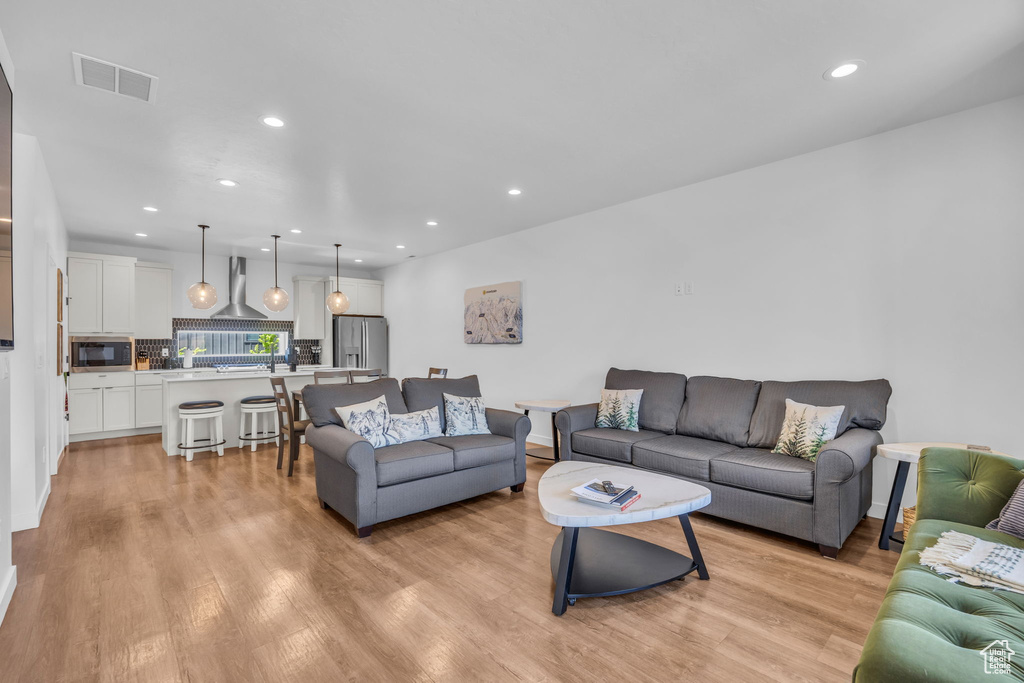 Living area with light wood-style floors and recessed lighting
