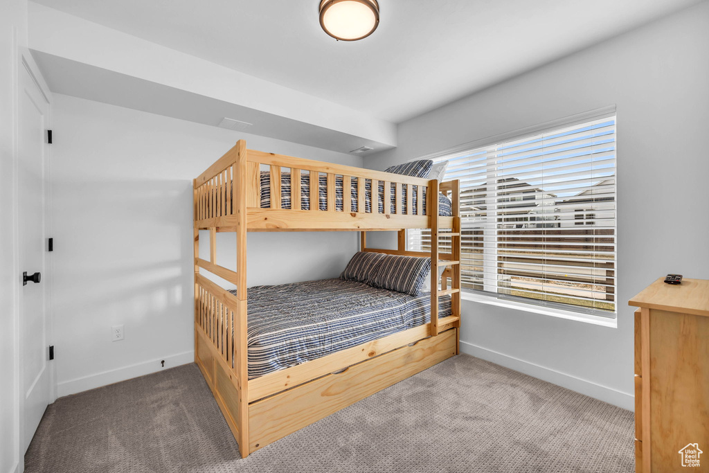 Carpeted bedroom featuring multiple windows