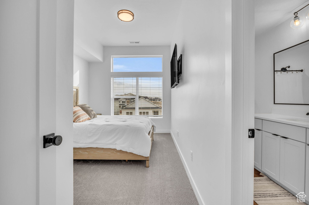 Bedroom featuring light carpet and baseboards