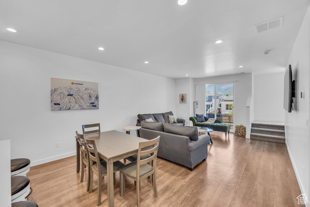 Dining space featuring light wood-type flooring, recessed lighting, and stairs