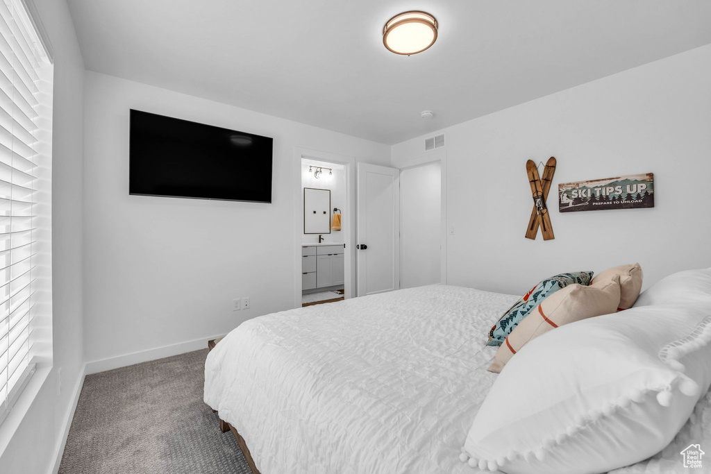 Carpeted bedroom with baseboards and ensuite bath