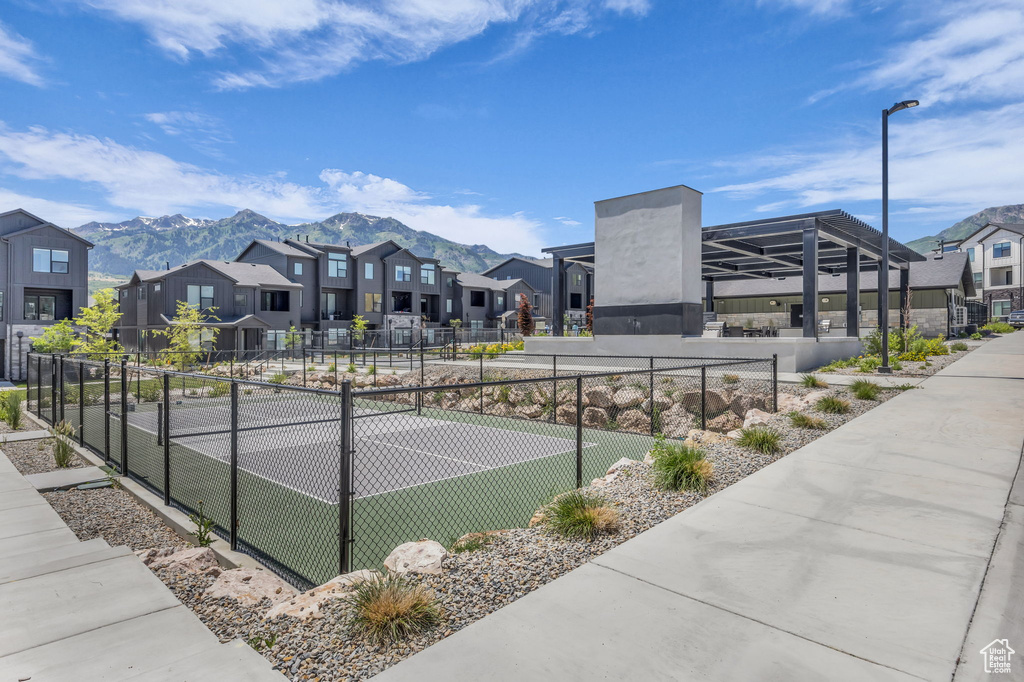 View of tennis court with a residential view and a mountain view