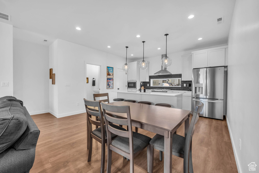 Dining room with light wood-type flooring and recessed lighting