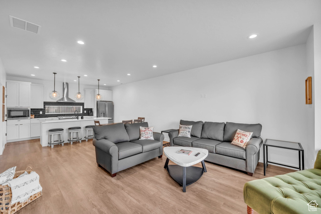 Living room with recessed lighting and light wood-style floors