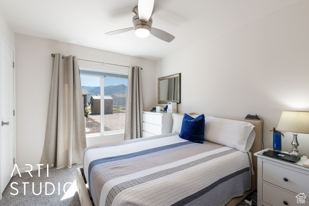 Carpeted bedroom featuring a mountain view and a ceiling fan