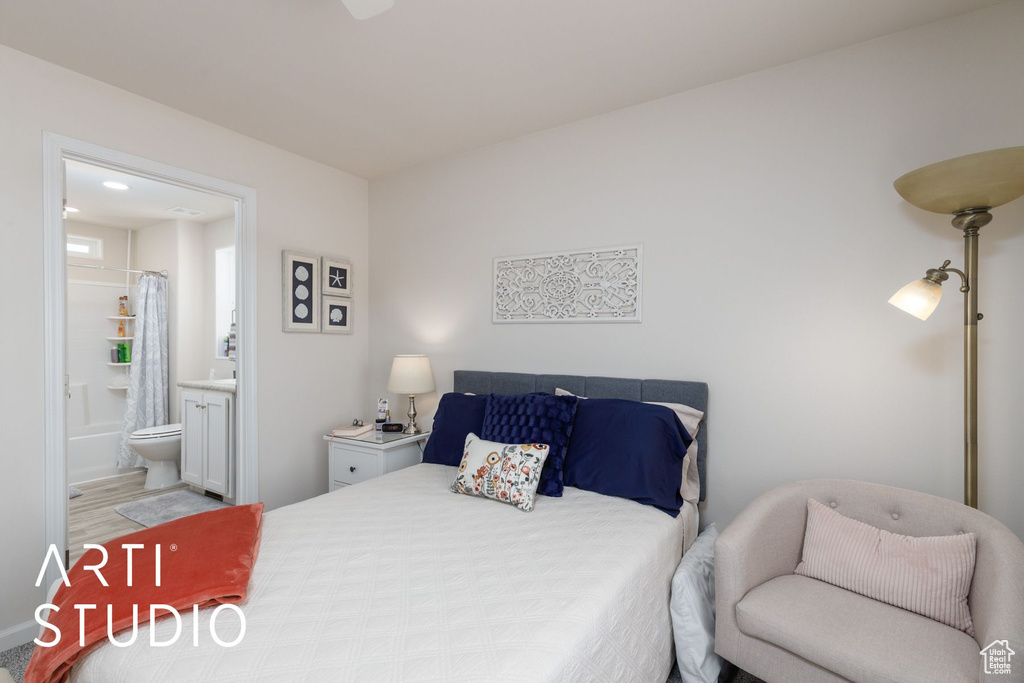 Bedroom with ensuite bath and wood finished floors