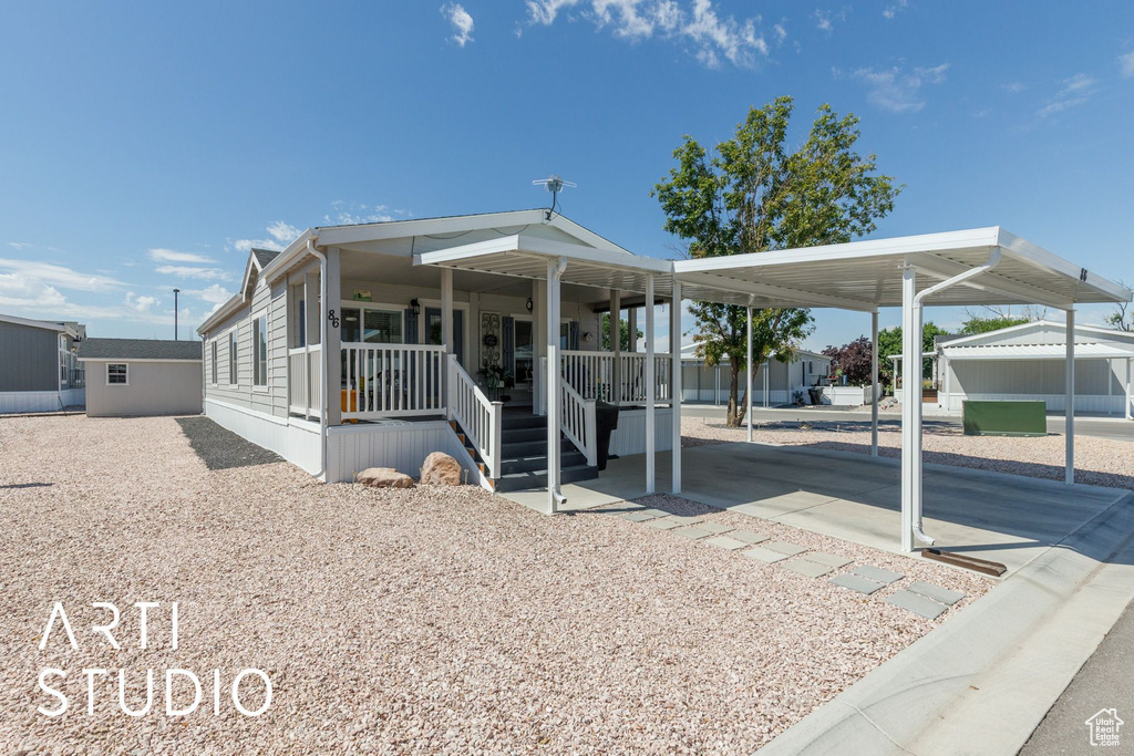 View of front of home featuring a carport, covered porch, and driveway