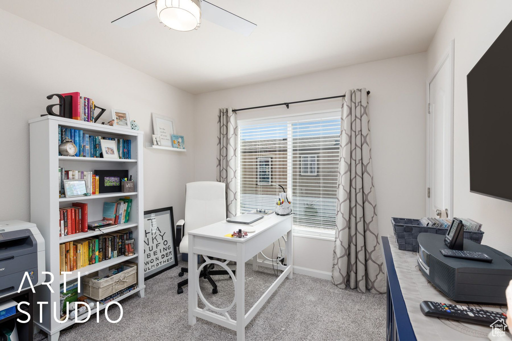 Carpeted office featuring ceiling fan and baseboards