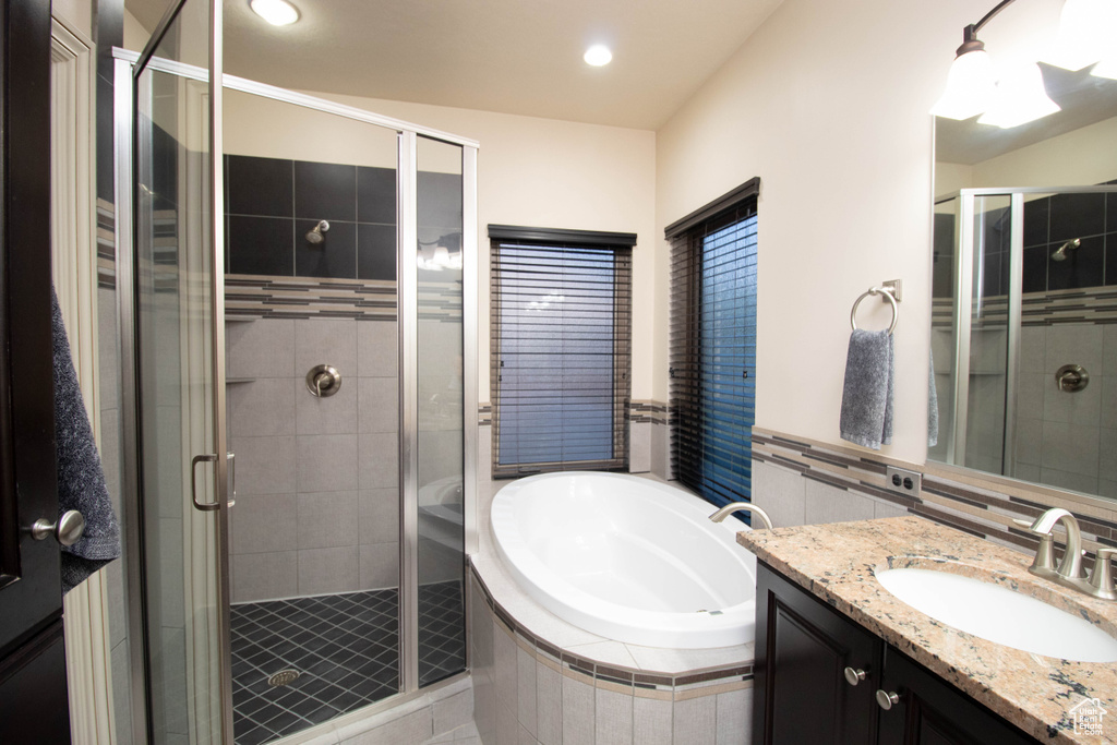 Full bathroom with vanity, a bath, a shower stall, and recessed lighting