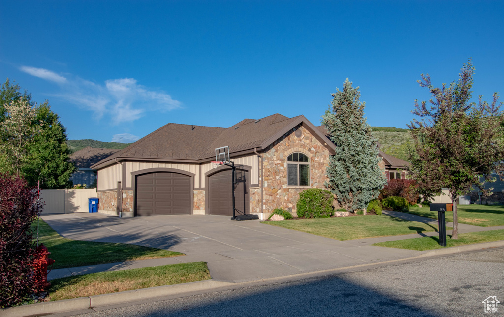 French country style house featuring an attached garage, stone siding, concrete driveway, and a shingled roof