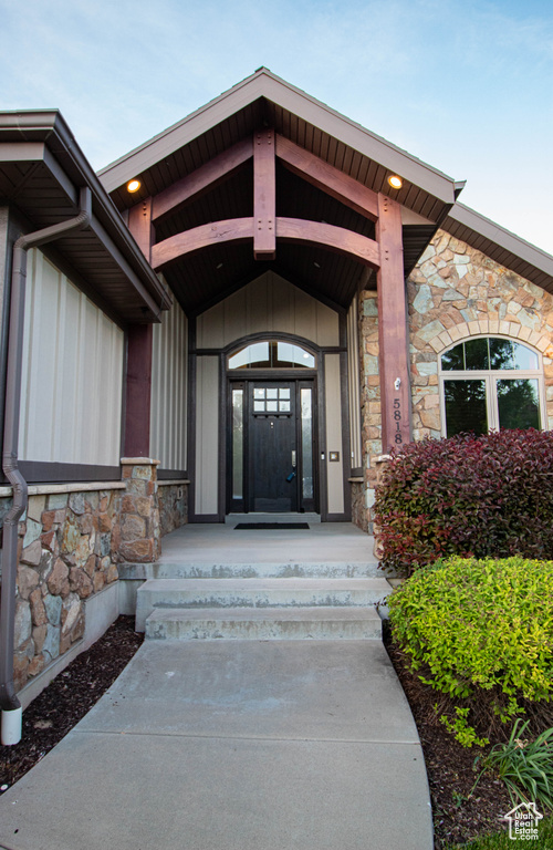 Entrance to property featuring stone siding and board and batten siding
