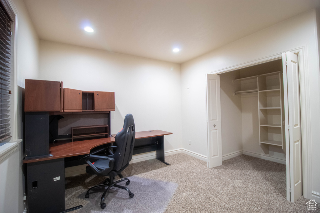 Home office with light colored carpet and recessed lighting