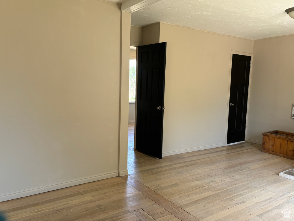 Unfurnished room featuring light wood-style flooring and a textured ceiling