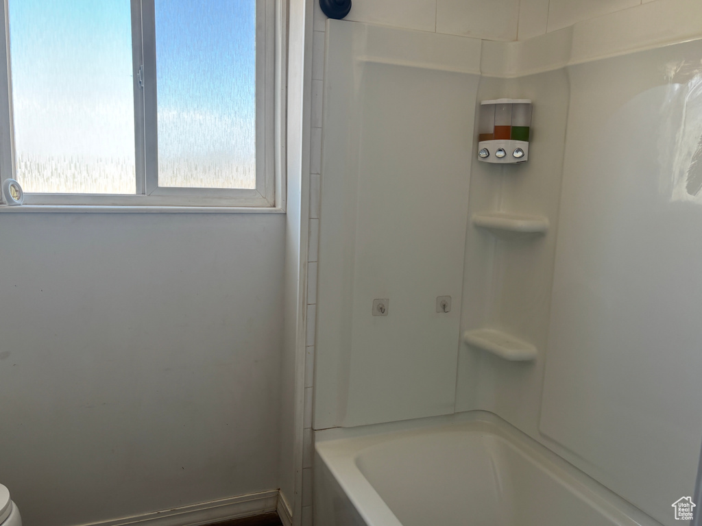 Bathroom featuring toilet and bathing tub / shower combination