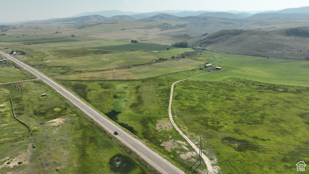Aerial view of property and surrounding area featuring rural landscape and a mountainous background