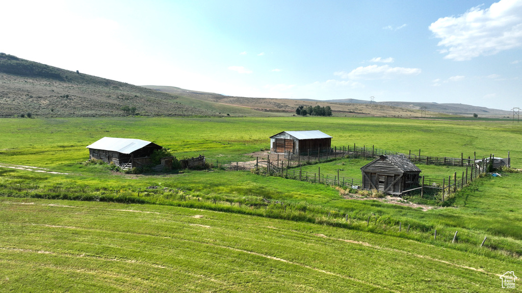View of yard featuring a view of countryside, an outdoor structure, a mountain view, and a pole building