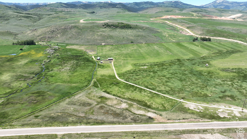 Aerial view of property and surrounding area featuring mountains and rural landscape
