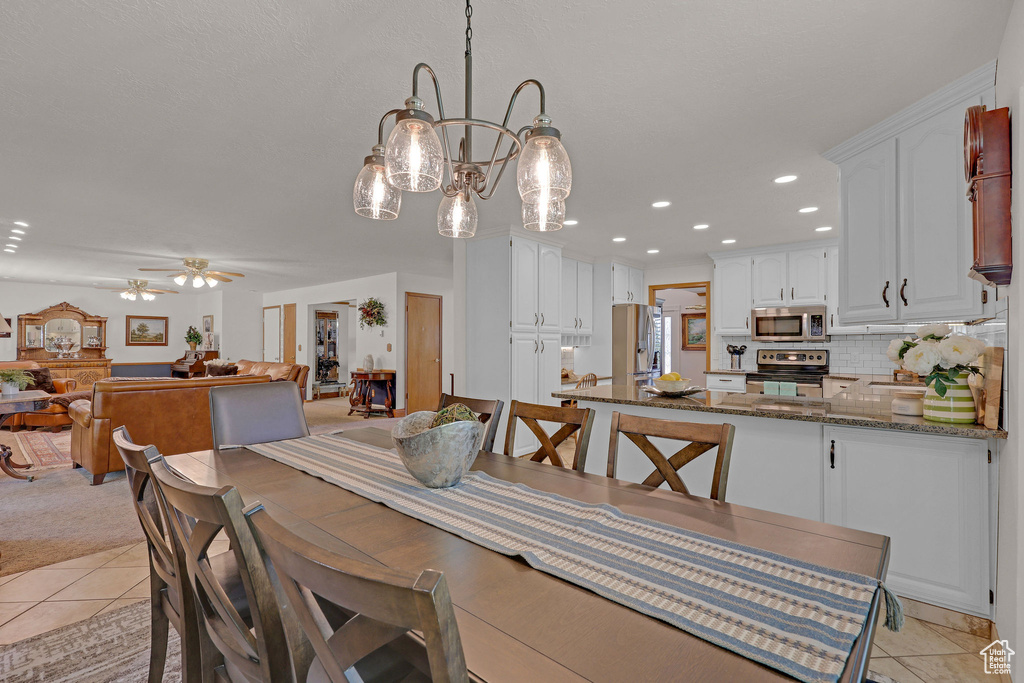 Dining space featuring light tile patterned flooring, a chandelier, recessed lighting, and a ceiling fan