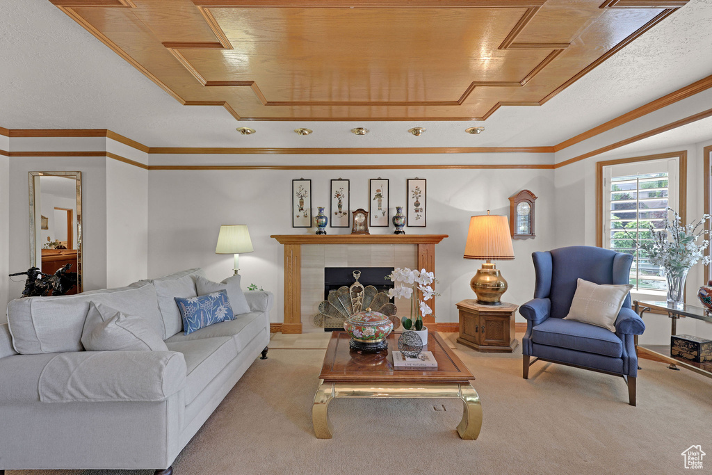 Living area featuring carpet, a tile fireplace, and ornamental molding