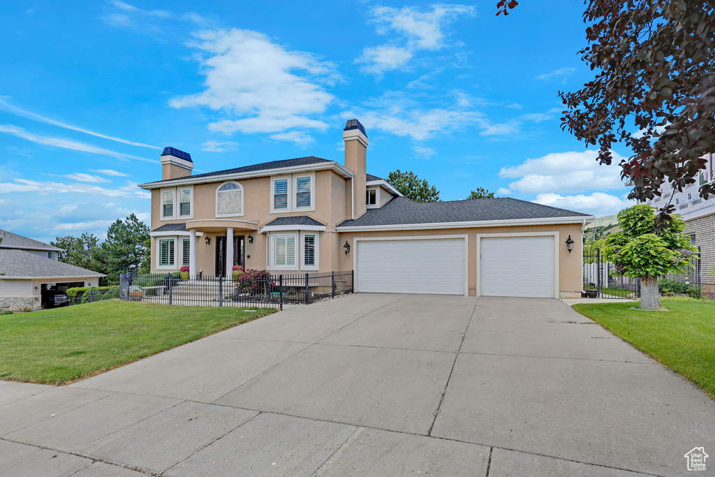 View of front of house featuring a chimney, driveway, a garage, and stucco siding