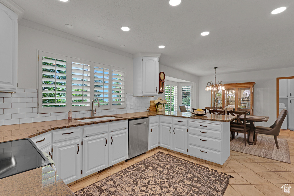 Kitchen featuring stainless steel dishwasher, recessed lighting, a peninsula, backsplash, and stone countertops