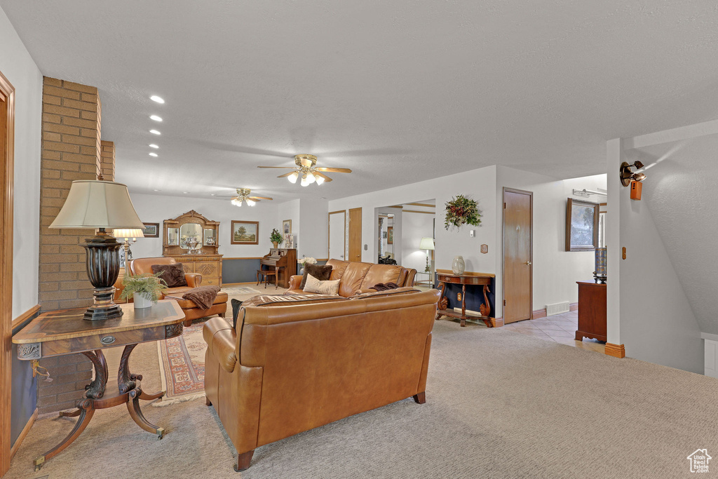 Living room featuring a ceiling fan and light carpet