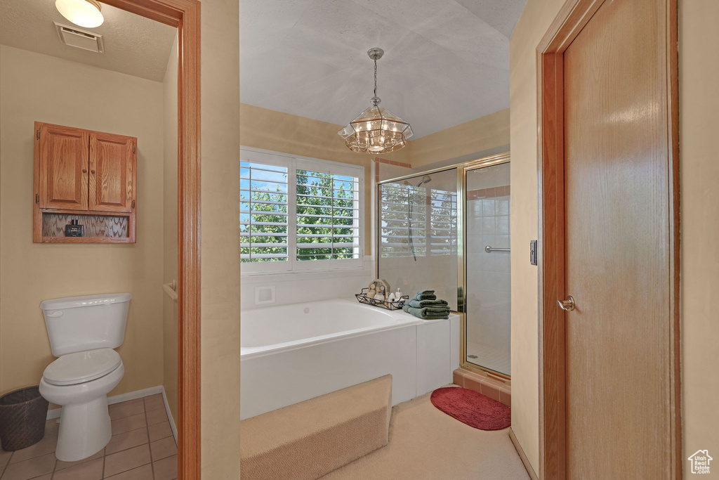 Bathroom with a garden tub, a chandelier, a stall shower, and tile patterned floors