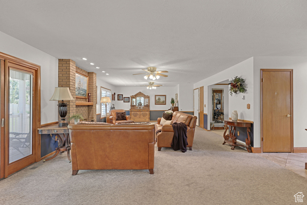 Living room with light carpet, a ceiling fan, and recessed lighting