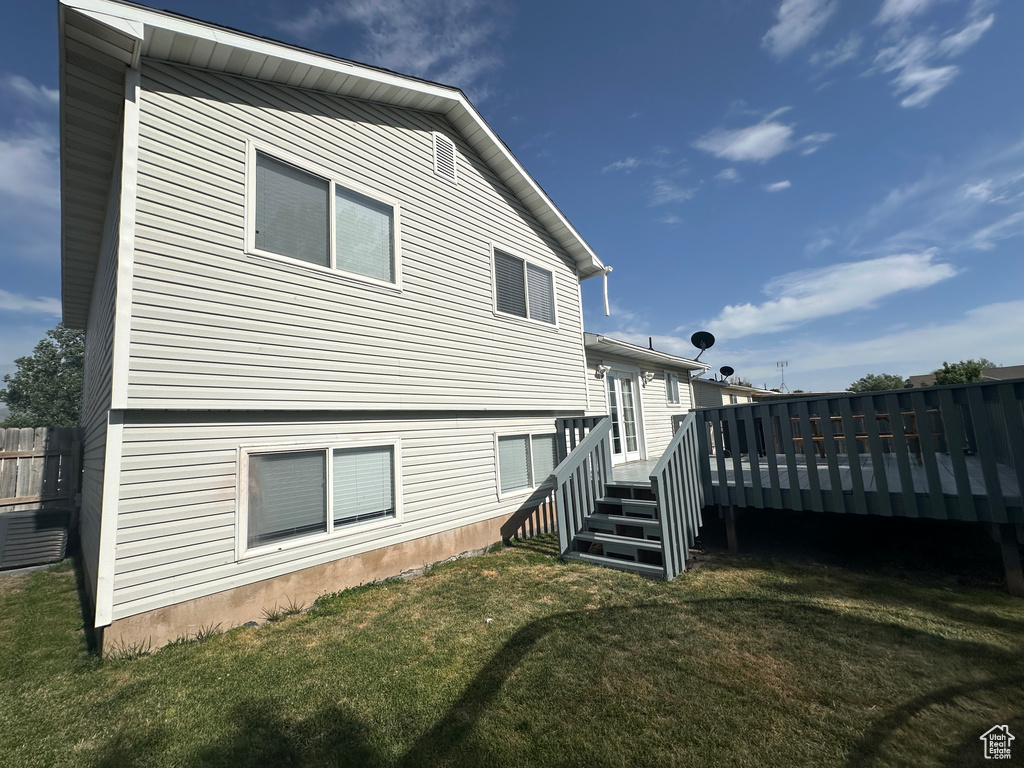 Back of property with a yard and a deck