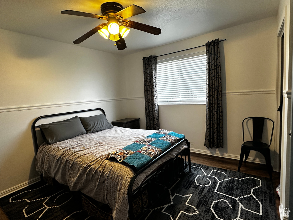 Bedroom with dark wood finished floors and a ceiling fan