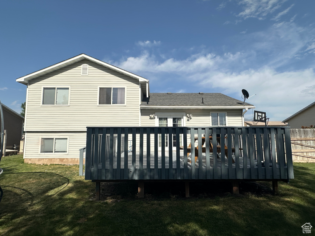 Back of property featuring a wooden deck and roof with shingles