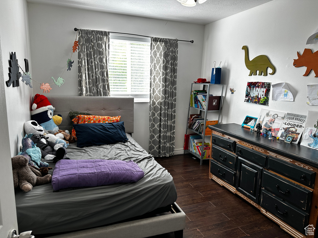Bedroom with dark wood-style floors and a textured ceiling
