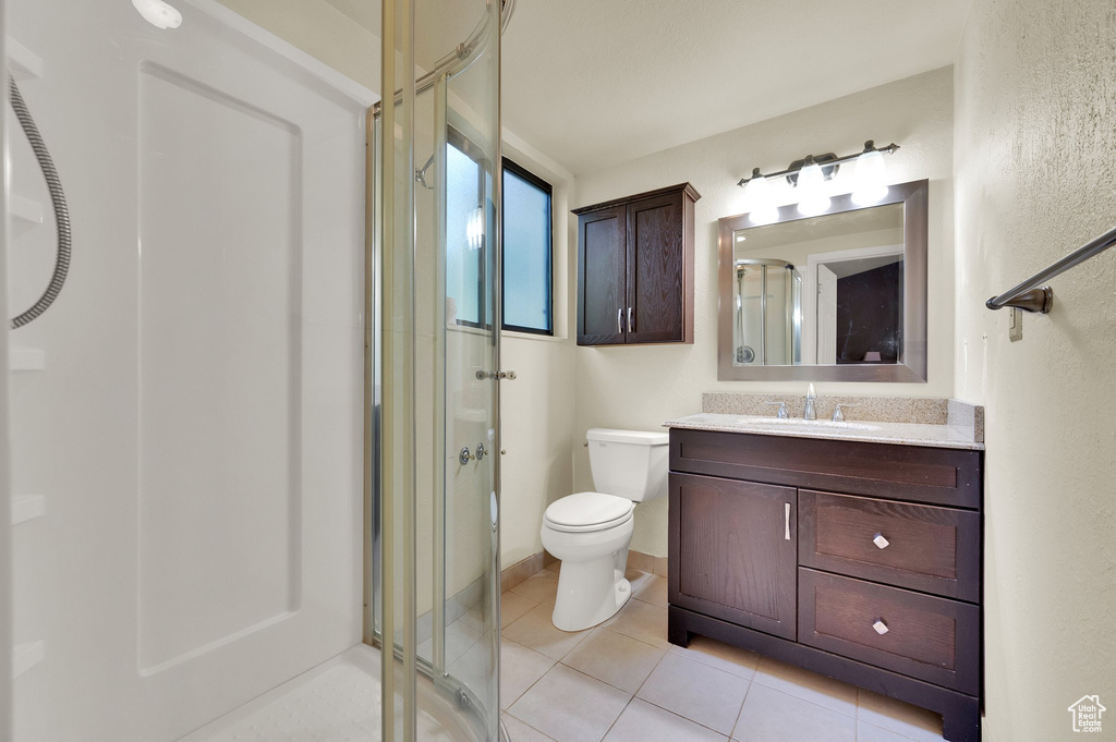 Full bathroom featuring a shower stall, vanity, and tile patterned flooring