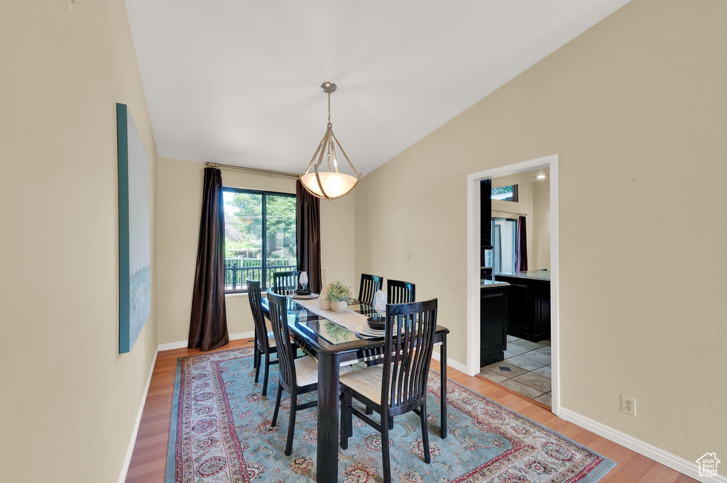 Dining room featuring light wood-type flooring and lofted ceiling