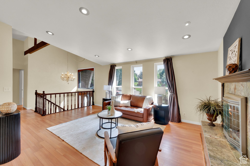 Living room featuring light wood finished floors, a chandelier, recessed lighting, and a fireplace
